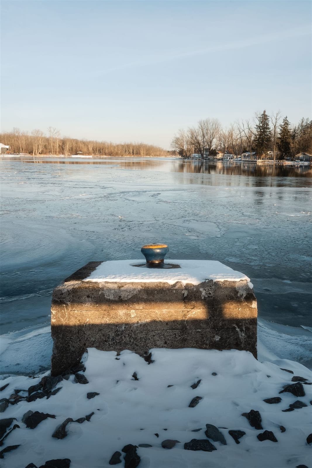 Plot de béton enneigé sur un lac gelé, au coucher du soleil